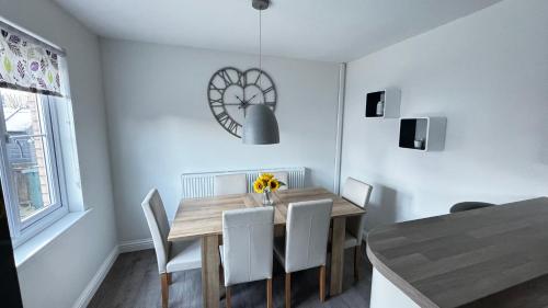 a dining room with a wooden table and white chairs at 6 Tobar Oisinn in Oban