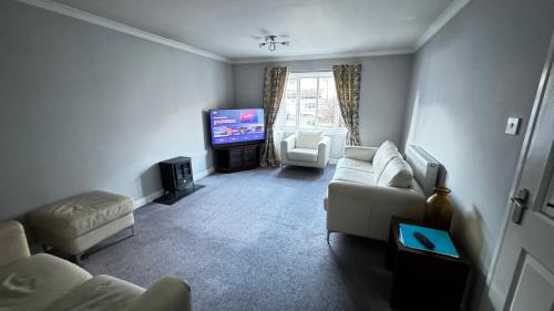 a living room with a couch and a tv at Tobar Oisinn in Oban