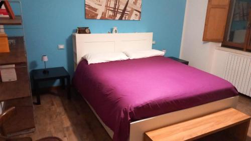 una camera da letto con un grande letto con una coperta viola di De L’Abbazia a Sulmona