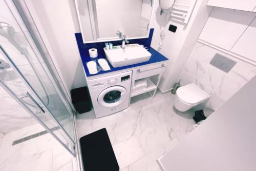 a bathroom with a washing machine and a sink at Rrrt in Batumi