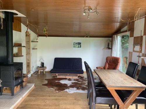 a living room with a table and a couch and a stove at Chalet hérisson in La Roche-en-Ardenne