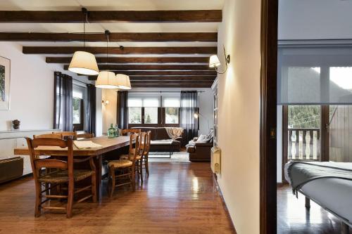 comedor y sala de estar con mesa y sillas en Luderna - Apartamento con terraza Bonaigua B2 Salient, en Baqueira Beret