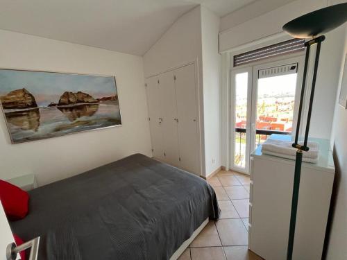 1 dormitorio con cama y ventana grande en Rocha Paradise, en Portimão