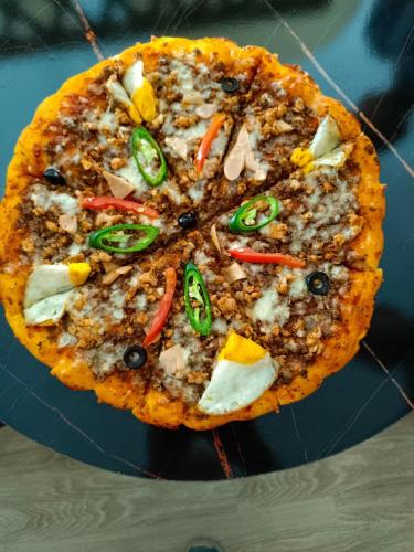 una pizza con diferentes ingredientes en un plato azul en Fenet Hawassa Hotel, en Āwasa