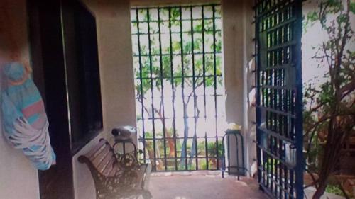 uma porta com um banco em frente a um portão em CASAMARAZUL Beach house em Santa Marta