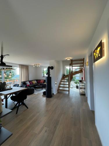 Il comprend un salon doté de parquet et d'un escalier. dans l'établissement Ferienhaus Mountain View Six53 mit Sauna und Kamin in St. Andreasberg, à Sankt-Andreasberg