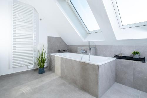 a bathroom with a bath tub and a skylight at Ferienhaus Mountain View Six53 mit Sauna und Kamin in St. Andreasberg in Sankt Andreasberg