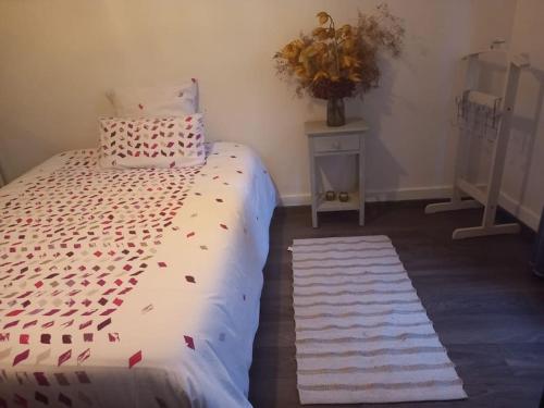 - une chambre avec un lit et un vase sur une table dans l'établissement Le Petit Nid Urbain, à Levallois-Perret