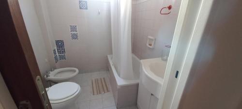 a white bathroom with a toilet and a sink at Casa Luz in Neuquén