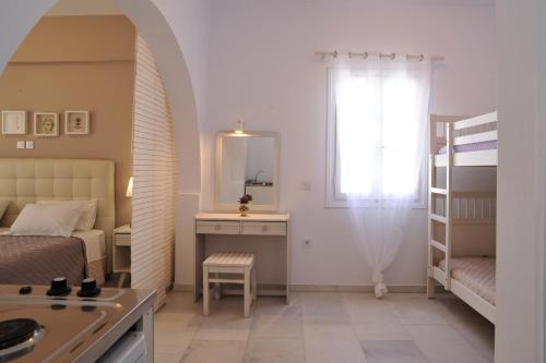 una piccola camera con letto e specchio di Scala Apartments a Kastraki