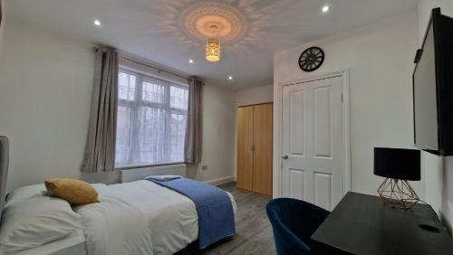ein Schlafzimmer mit einem Bett und einer Uhr an der Decke in der Unterkunft Elegant 2-Bedroom Double En-Suite Flat - London in Wanstead
