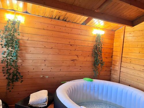 a bathroom with a tub in a wooden wall at Ashford Home - Spacious house close to Ashford International and free drive parking and hot tub in Ashford