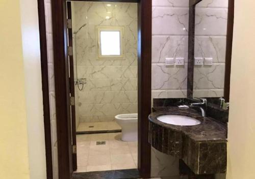 a bathroom with a sink and a toilet at اجنحة كنوز in Jeddah