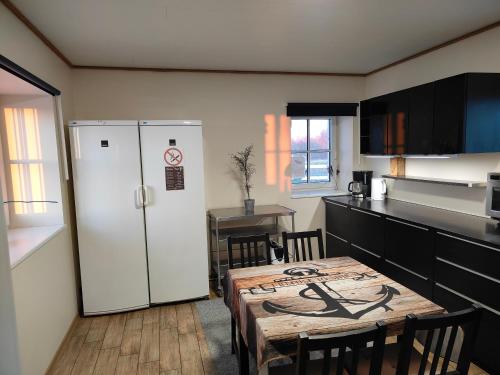 a kitchen with a table and a white refrigerator at Pakri Parun in Paldiski