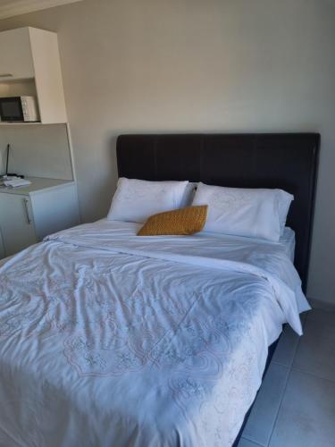 a bed with a black headboard and white pillows at 5 AntiP in Cape Town