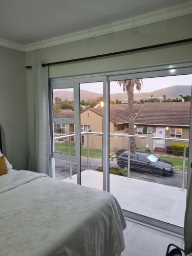 a bedroom with a large window with a view of a car at 5 AntiP in Cape Town