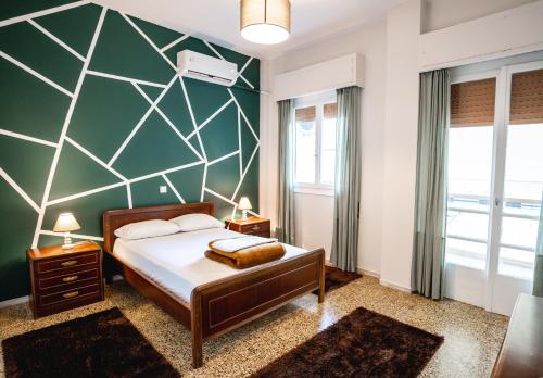 ein Schlafzimmer mit einem Bett und einer grünen Wand in der Unterkunft Apartment 105 sq.m. near center in Patras