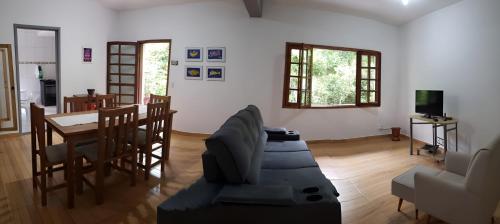 a living room with a couch and a table and chairs at Casa do Lago in Cunha