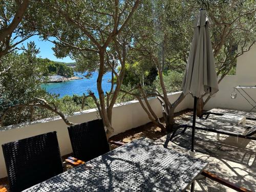 a table with an umbrella and a view of the water at Villa Hosta Apartments in Hvar