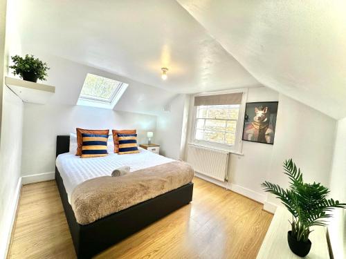 Enticing 2 Bed 2 Bath Flat in Hackney with garden في لندن: غرفة نوم عليها سرير ووسادتين