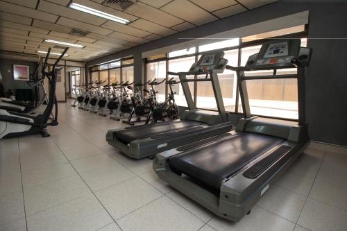 a gym with rows of treadmills and elliptical machines at GH Gran Hotel - Downtown Medellin in Medellín