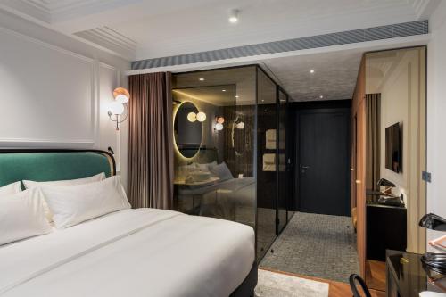 1 dormitorio con cama blanca y baño en AS Boutique Hotel, superior, en Liubliana