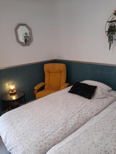 - une chambre avec un lit et une chaise orange dans l'établissement Location studio meublé Curistes., à Balaruc-les-Bains