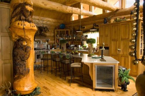 a kitchen with a counter and a bar with stools at LUXURIOUS TN Mtn Lodge- Sleeps 22+, Hiking & Lake in Butler