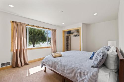 a bedroom with a bed and a large window at Lakefront Gem with Hot tub and Views in Sandpoint