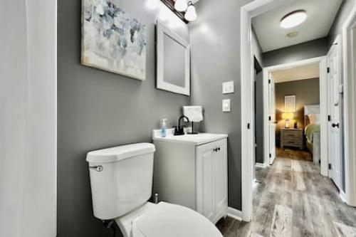 a white bathroom with a toilet and a sink at Sleek remodeled Design 2 Bed Trenton, OH Apartment in Trenton