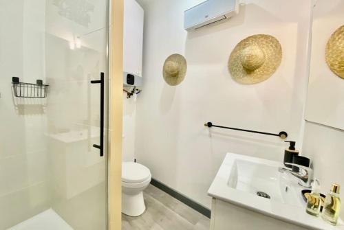 a white bathroom with a toilet and a sink at Le Kozy - Chambre hôtel en plein coeur de ville in Nîmes