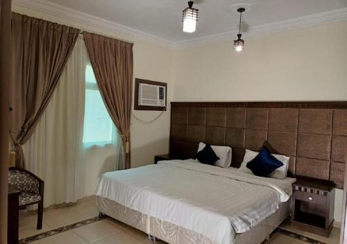 um quarto com uma cama grande e almofadas azuis em فندق الافاق بالنسيم em Jeddah