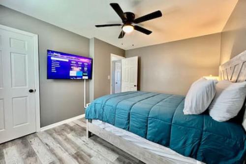 a bedroom with a bed with a ceiling fan and a tv at Charming, Stylish remodeled Trenton Apartment in Trenton