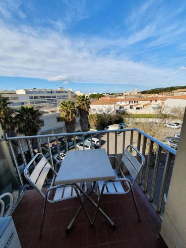 une table et des chaises sur un balcon avec vue dans l'établissement Location studio meublé Curistes., à Balaruc-les-Bains