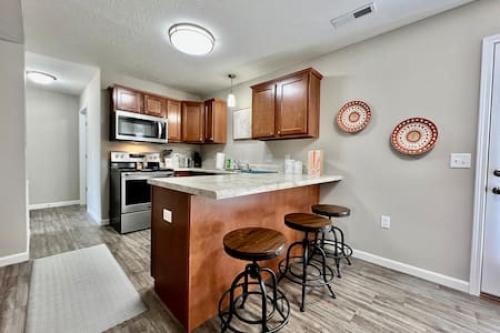 a kitchen with a counter and stools in it at Brand New Home Walking distance to Spooky Nook in Hamilton
