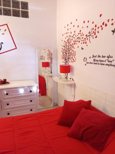 um quarto com uma cama com lençóis vermelhos e um espelho em Dalla Rossa em Montelupo Fiorentino