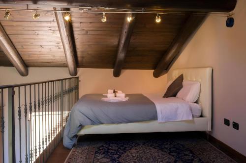 - une chambre avec un lit dans une pièce dotée de plafonds en bois dans l'établissement Splendida Casa in Centro a Barbaresco, à Barbaresco