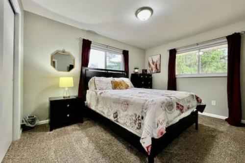 1 dormitorio con cama, espejo y ventanas en Beautiful home Among trees outside the city, en Dent