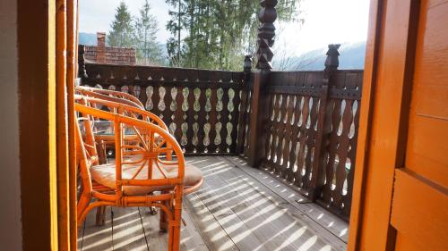 a balcony with two chairs and a table on it at Evergreen Balvanyos in Balvanyos