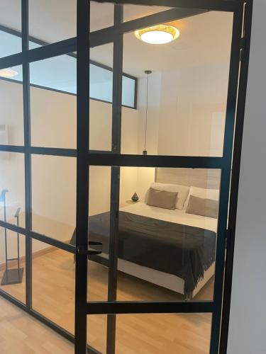 een slaapkamer met een bed door een glazen raam bij Soho Moraleja I in Alcobendas