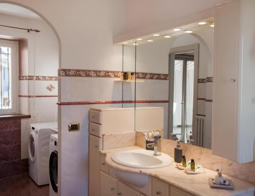 La salle de bains est pourvue d'un lavabo et d'un grand miroir. dans l'établissement Splendida Casa in Centro a Barbaresco, à Barbaresco