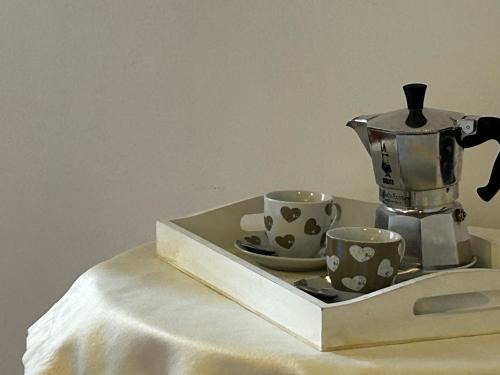 a serving tray with two cups and a coffee maker at Ai piedi del castello / 4PL / Apt. FULL in Verona
