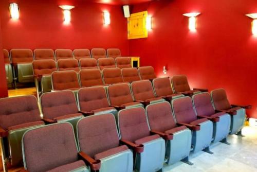 an auditorium with red walls and empty chairs at Suite Maharaja in Stanardsville