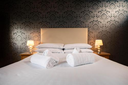 a bedroom with a white bed with towels on it at The Manor in St Bees