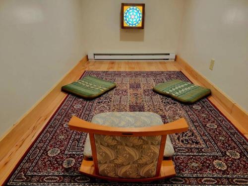 a room with a table and two pillows on a rug at White Lotus Suite in Stanardsville