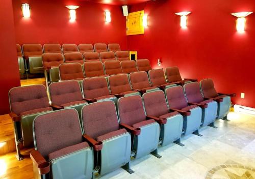 an empty auditorium with red walls and brown chairs at White Lotus Suite in Stanardsville
