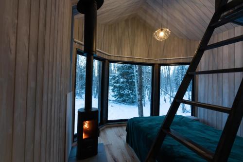 a bedroom in a tree house with a bed and a fireplace at Paunküla Nature Resort (forest villa) in Ardu