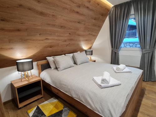 um quarto com uma cama com duas toalhas em Bajkoviti bungalov em Pale