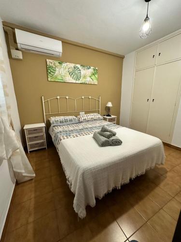 1 dormitorio con 1 cama grande con colcha blanca en EL PARAISO Piscina y Vistas a la costa, en Mijas