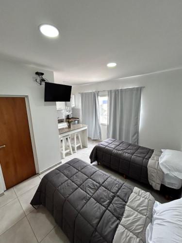 a hotel room with two beds and a flat screen tv at Plaza Km 325 in San Lorenzo